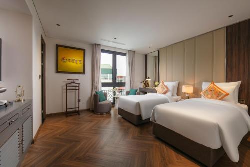 a hotel room with two beds and a desk at Léman Old Quarter in Hanoi