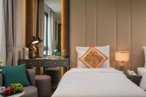 a hotel room with a bed and a chair at Léman Old Quarter in Hanoi