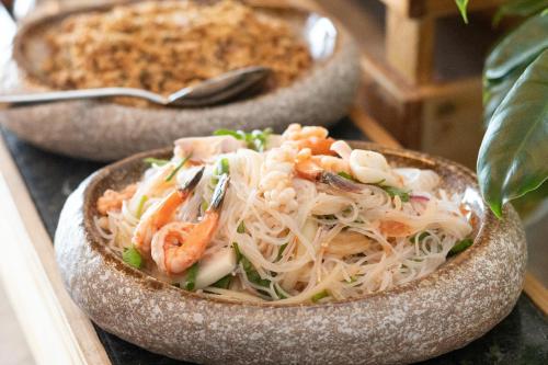two bowls of food with shrimp and noodles on a table at Sensory Park Urban Hotel in Phnom Penh