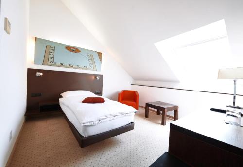 a bedroom with a bed and a desk and a chair at Hotel la Meridiana, Lake & SPA in Ascona