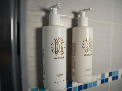 two white shampoo bottles sitting on a bathroom counter at Ludwig Boutique Hotel & Spa in Bolsena