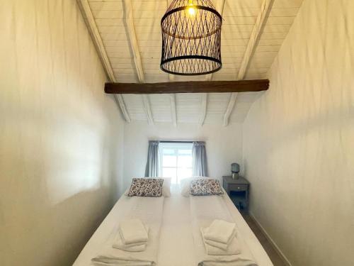 a bed in a room with a window and a chandelier at Holiday Homes in Ubachsberg with a Picturesque Garden in Ubachsberg