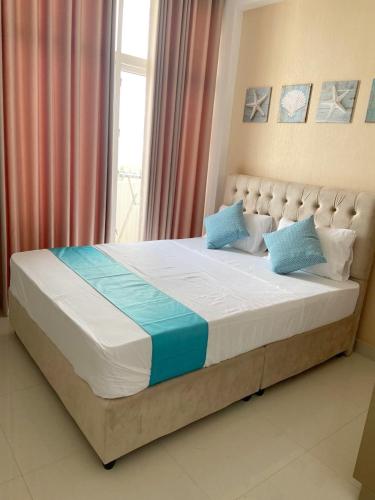 a large bed in a room with a window at Marine Blue Apartment in Dehiwala