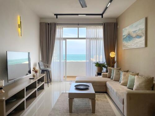 a living room with a couch and a large window at Marine Blue Apartment in Dehiwala
