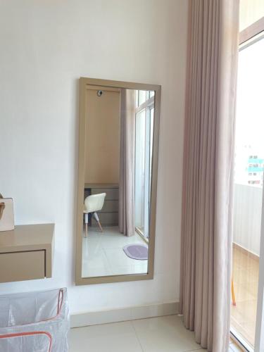 a mirror in a room with a chair and a window at Marine Blue Apartment in Dehiwala