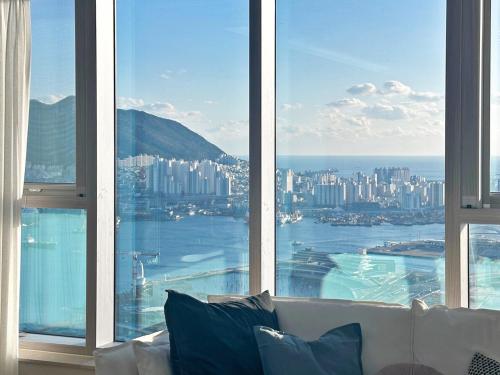 a room with a white couch in front of a large window at Brown Suites Busan Station in Busan