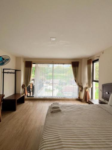 a large bedroom with a bed and a large window at wisma rotterdam in Madandan