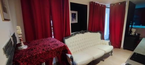 a room with a white chair and red curtains at Loveroom Chambre obscure in Saint-Amarin