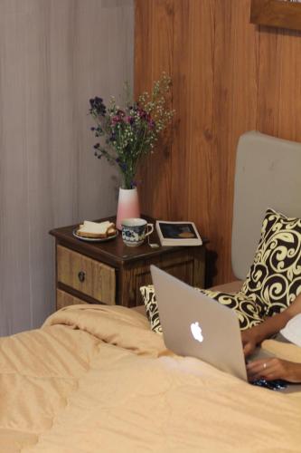 a laptop computer sitting on top of a bed at Candra Dewi Yogyakarta in Timuran