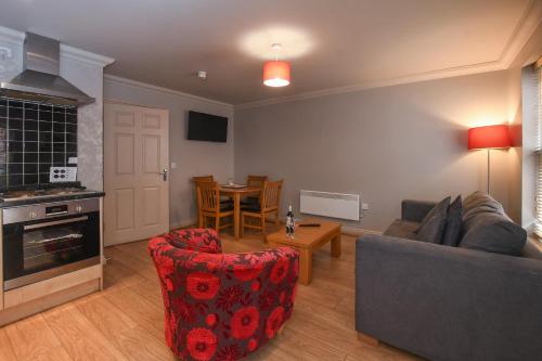 a living room with a couch and a table at The Queens Hotel & Victoria Cloisters Apartments in York