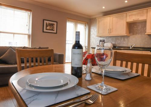 a table with a bottle of wine and a glass at The Queens Hotel & Victoria Cloisters Apartments in York