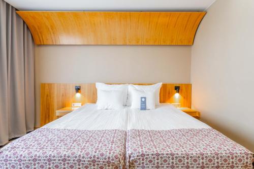 a bedroom with a large bed with a wooden ceiling at Hestia Hotel Europa in Tallinn