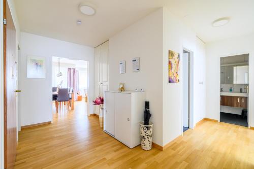 a white apartment with a wooden floor and white walls at Apartment Arnold in Basel