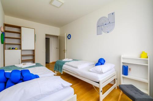 two beds in a room with blue and white at Apartment Arnold in Basel
