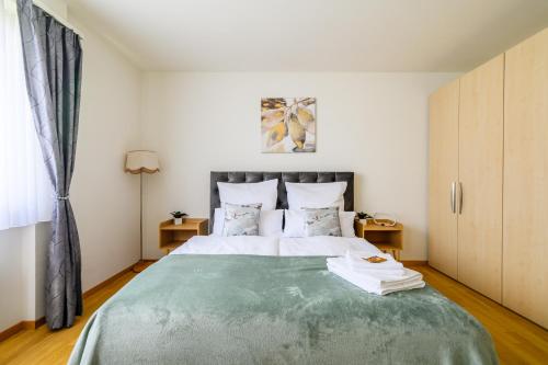 a bedroom with a large bed with a green blanket at Apartment Arnold in Basel