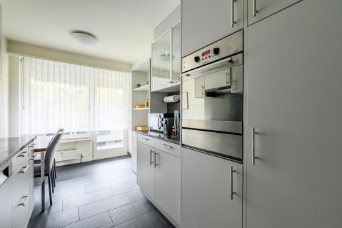 a kitchen with white cabinets and a counter top at Apartment Arnold in Basel