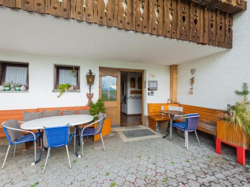 a patio with a table and chairs and a building at Chalet in Schwarzenberg am Skilift in Schwarzenberg
