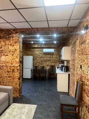 pokój ze ścianami z cegły, kuchnią i kanapą w obiekcie Apartament w centrum w mieście Horyniec
