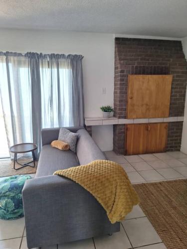 a living room with a gray couch and a fireplace at Beach Front 4 in Hentiesbaai