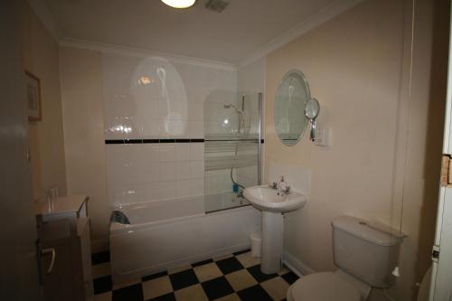 a bathroom with a sink and a toilet and a tub at The Clothiers Arms in Stroud