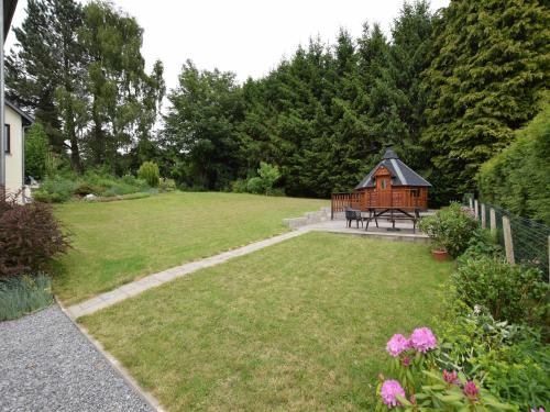 a garden with a bench and a wooden cabin at Lakeview Stay in Vielsalm in Vielsalm