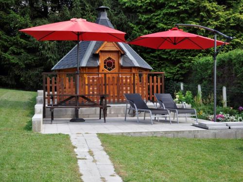 a gazebo with two chairs and a red umbrella at Lakeview Stay in Vielsalm in Vielsalm