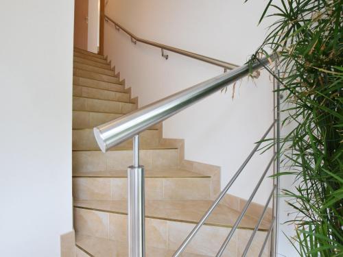 a staircase with a stainless steel handrail and wooden stairs at Lakeview Stay in Vielsalm in Vielsalm