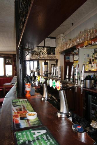 a bar in a pub with a counter with drinks at The Clothiers Arms in Stroud