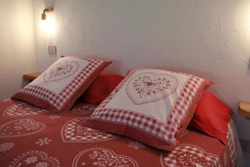 a bed with two red and white pillows on it at La Petite Marguerite in Bionaz