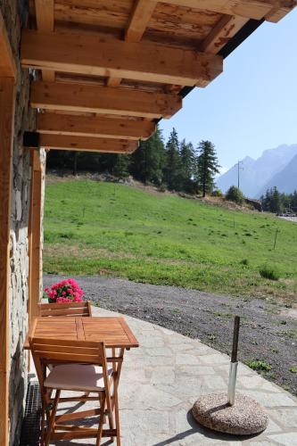 a wooden table and chairs on a patio at La Petite Marguerite in Bionaz