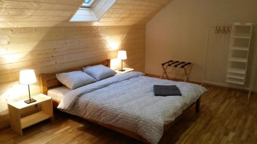 a bedroom with a bed and two lamps on tables at Apartamenty Jezioro i Las Mazury in Powałczyn