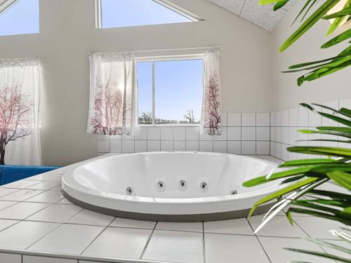 a large white tub in a bathroom with a window at Luxury Beach House - By Traum Ferienwohnungen in Bagenkop