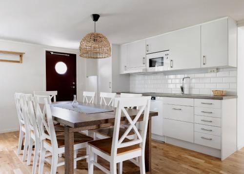 a kitchen with a wooden table and white cabinets at Visby Gustavsvik in Visby