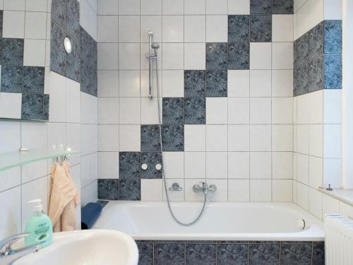 a bathroom with a tub and a sink at Holiday homes for two people, with a swimming pool, in the Ore Mountains in Pockau