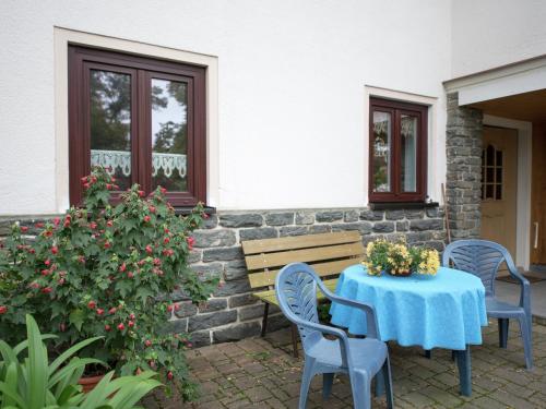 a table with a blue table cloth on a patio at Holiday homes for two people, with a swimming pool, in the Ore Mountains in Pockau