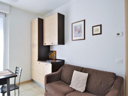 un soggiorno con un divano marrone e una cucina di Simplistic apartment in Dervio with balcony terrace a Dervio
