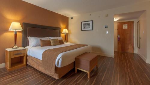 a hotel room with a large bed and two lamps at Coast Hillcrest Hotel in Revelstoke