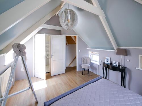 a bedroom with a ladder and a desk in a attic at Beautiful Apartment in Callantsoog near Beach in Callantsoog