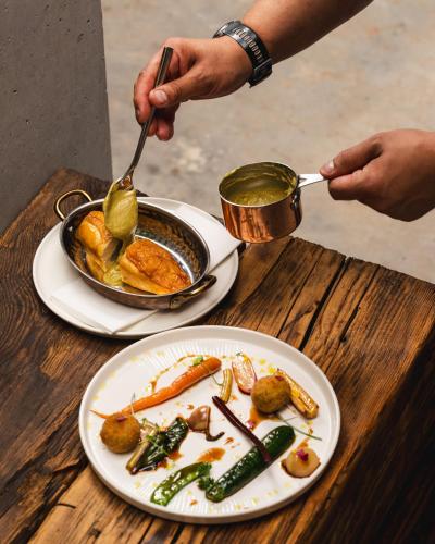 a table with two plates of food and a pan of food at ARCHE Klasztor Wrocław in Wrocław