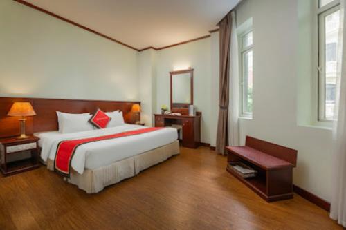 a bedroom with a large bed and a mirror at Sunny Hotel in Hanoi