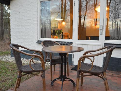 a table and four chairs on a patio at Completely detached bungalow in a nature-filled park by a large fen in Stramproy