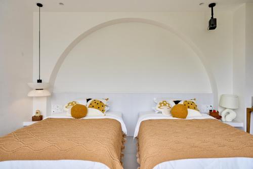 two beds in a white room with two beds sidx sidx sidx at Miyue Shenzhen Blue and White Holy Island Cliff Pool Hotel in Shenzhen