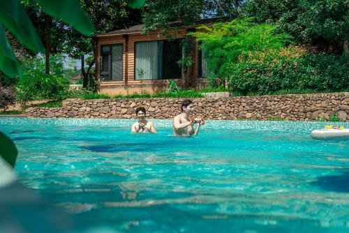 two boys are swimming in a swimming pool at Anji Pu An Tea House Hotel in Anji
