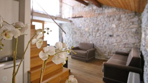 a living room with a couch and a vase with white flowers at Italianway - Torno in Torno