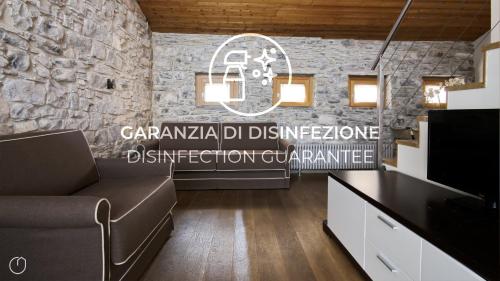 a living room with a couch and a stone wall at Italianway - Torno in Torno