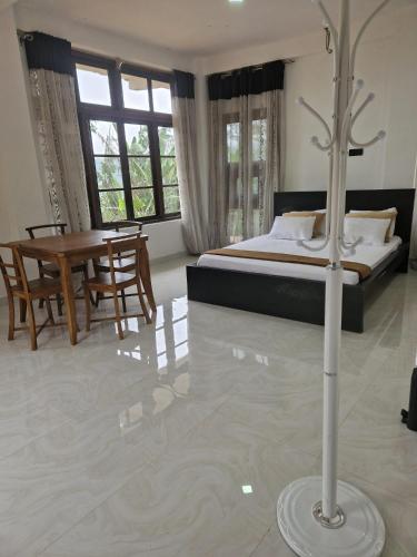 a bedroom with a bed and a table in a room at Aruni Villa - Knuckles Range 