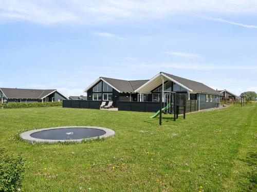 a house with a playground in front of a house at 5 star holiday home in Bogense in Bogense