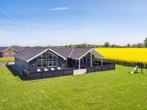 a black house in a field of grass at 5 star holiday home in Bogense in Bogense