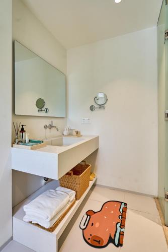 a bathroom with a sink and a mirror at Miyue Shenzhen Blue and White Holy Island Cliff Pool Hotel in Shenzhen