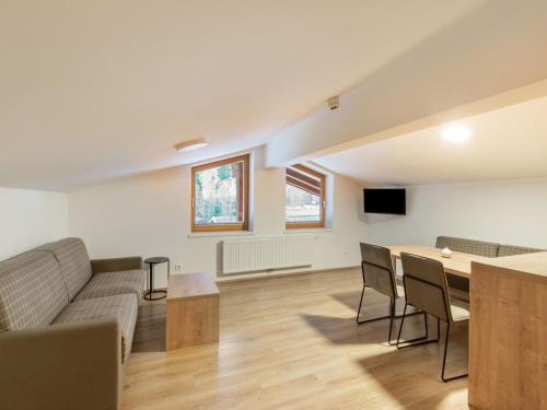 a living room with a couch and a table at Lovely Apartment with Sauna, Ski Storage, Pool, Terrace in Wald im Pinzgau